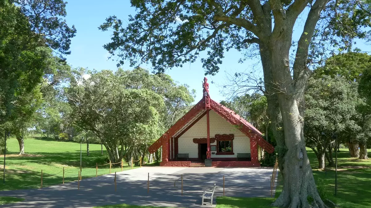 Maori meeting house Te Whare Runanga surrounded by trees and grass at Waitangi Treaty Grounds. Main Image
