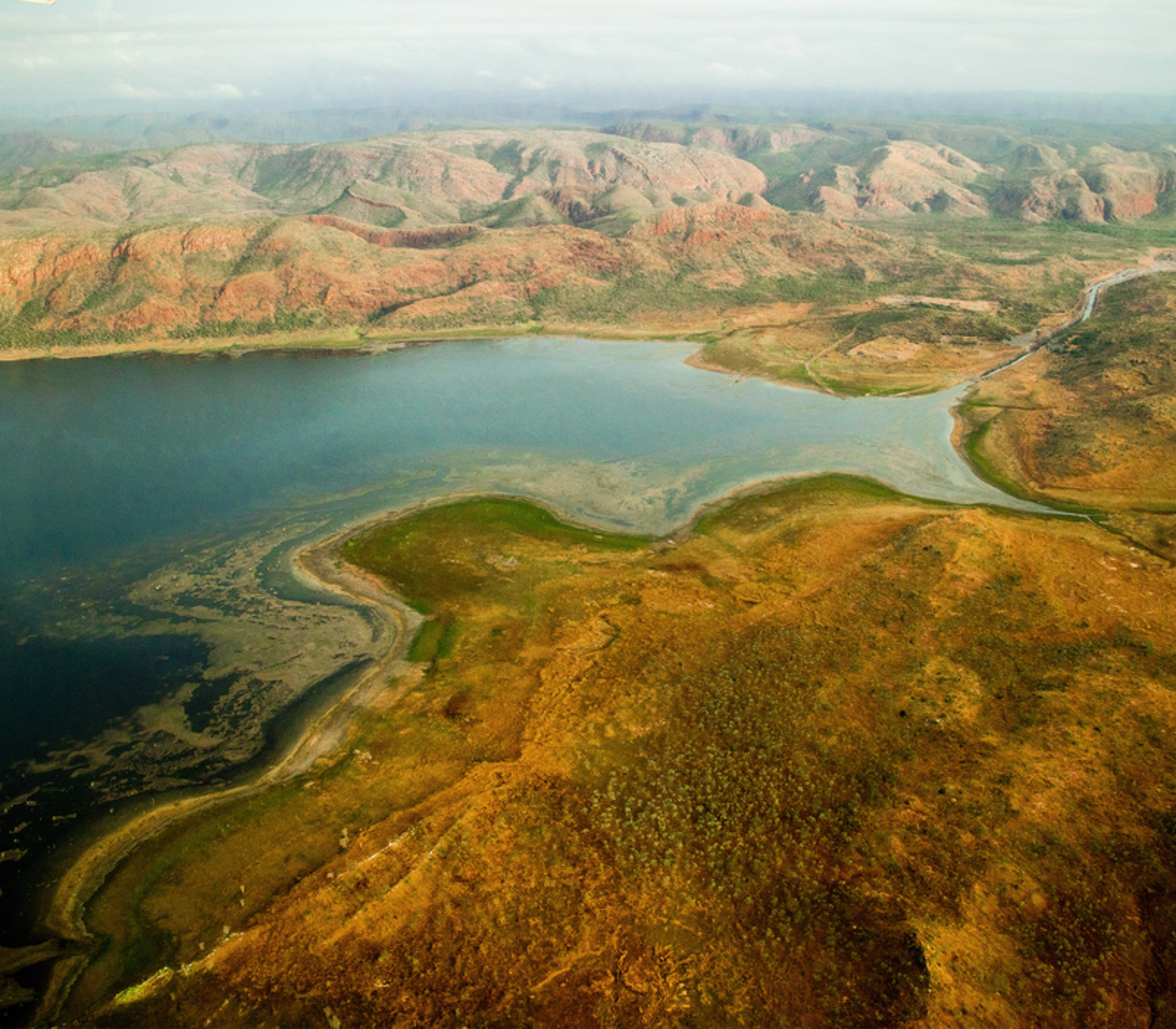 Aerial perspective of Lake Argyle and the rocky red terrain of the Kimberley region in Western Australia.