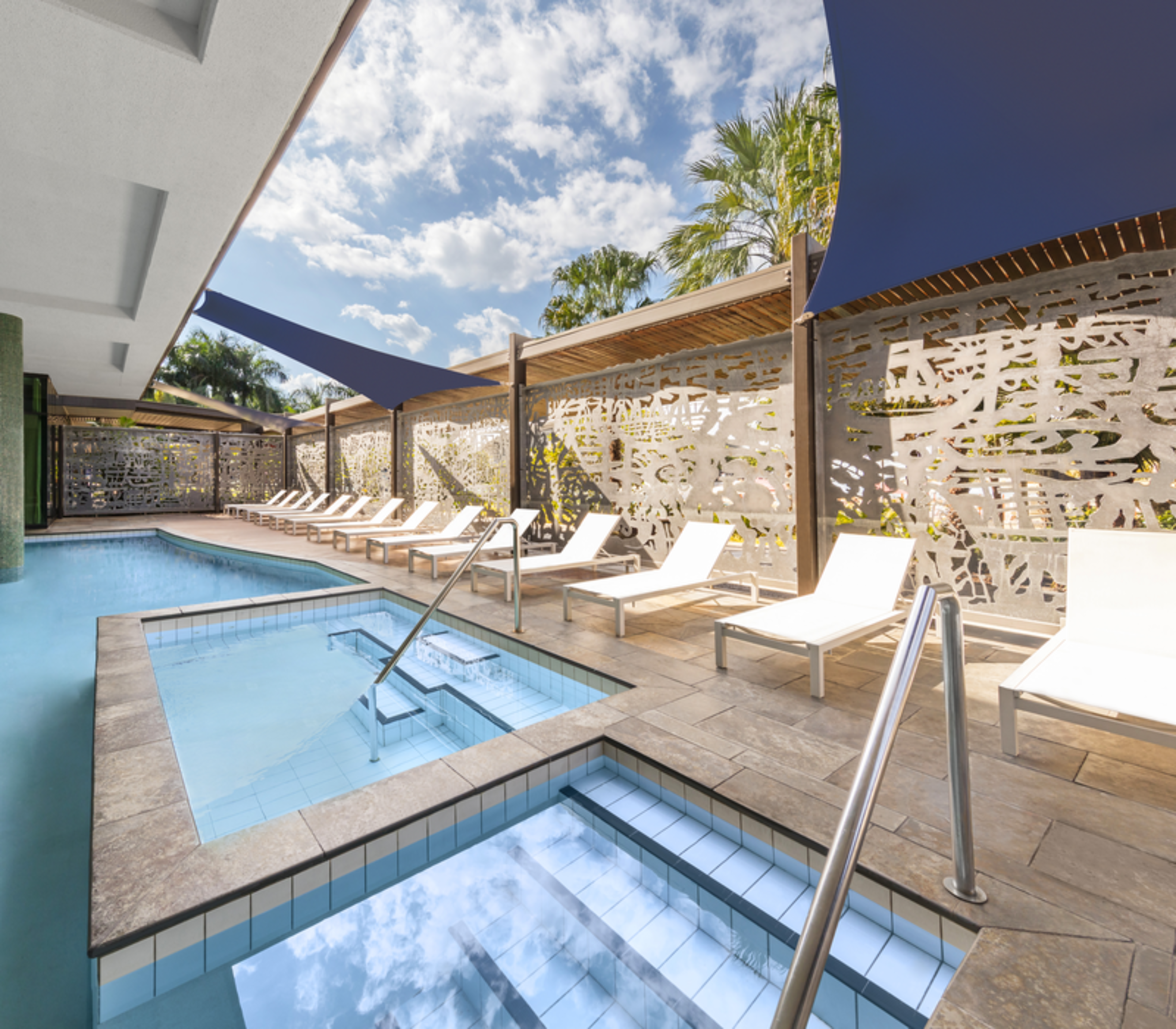 Modern king hotel room with light timber accents and harbour views in Darwin NT.