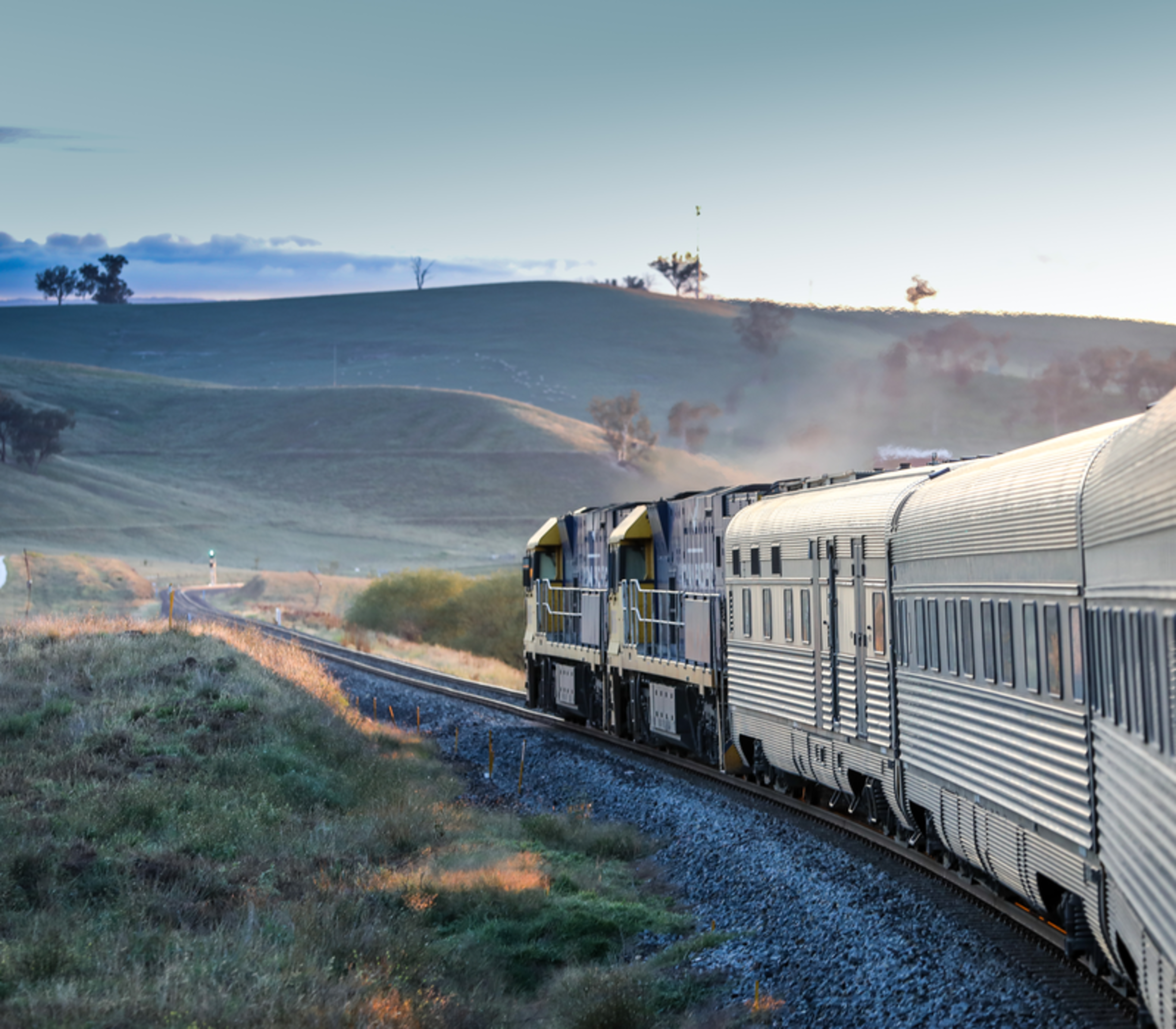 View from the window of the Indian Pacific train as it rounds a curve through the grassy hills of the Blue Mountains, New South Wales.