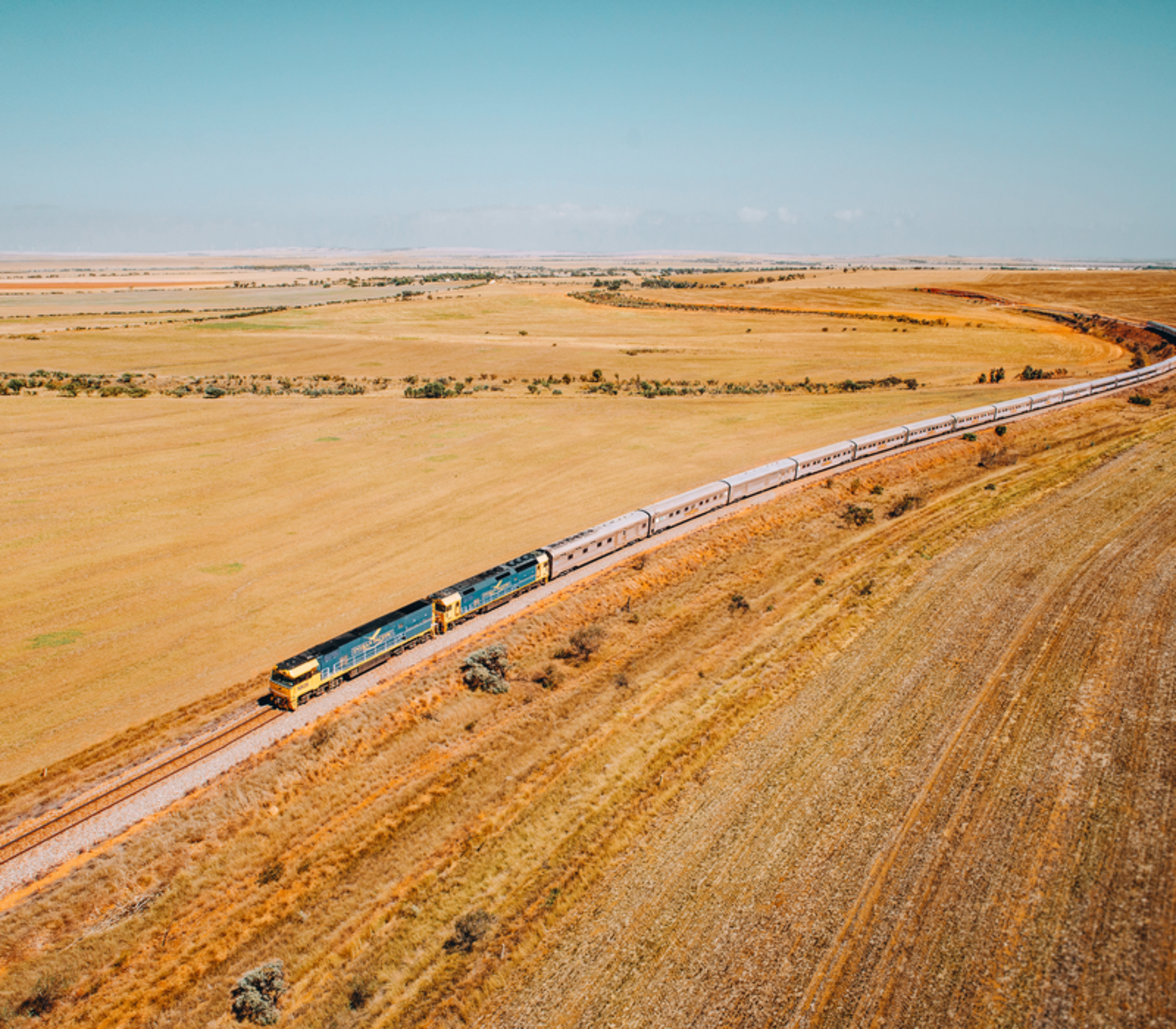 A cinematic aerial "hero shot" of the iconic Indian Pacific train winding through Clare Valley, SA. 
