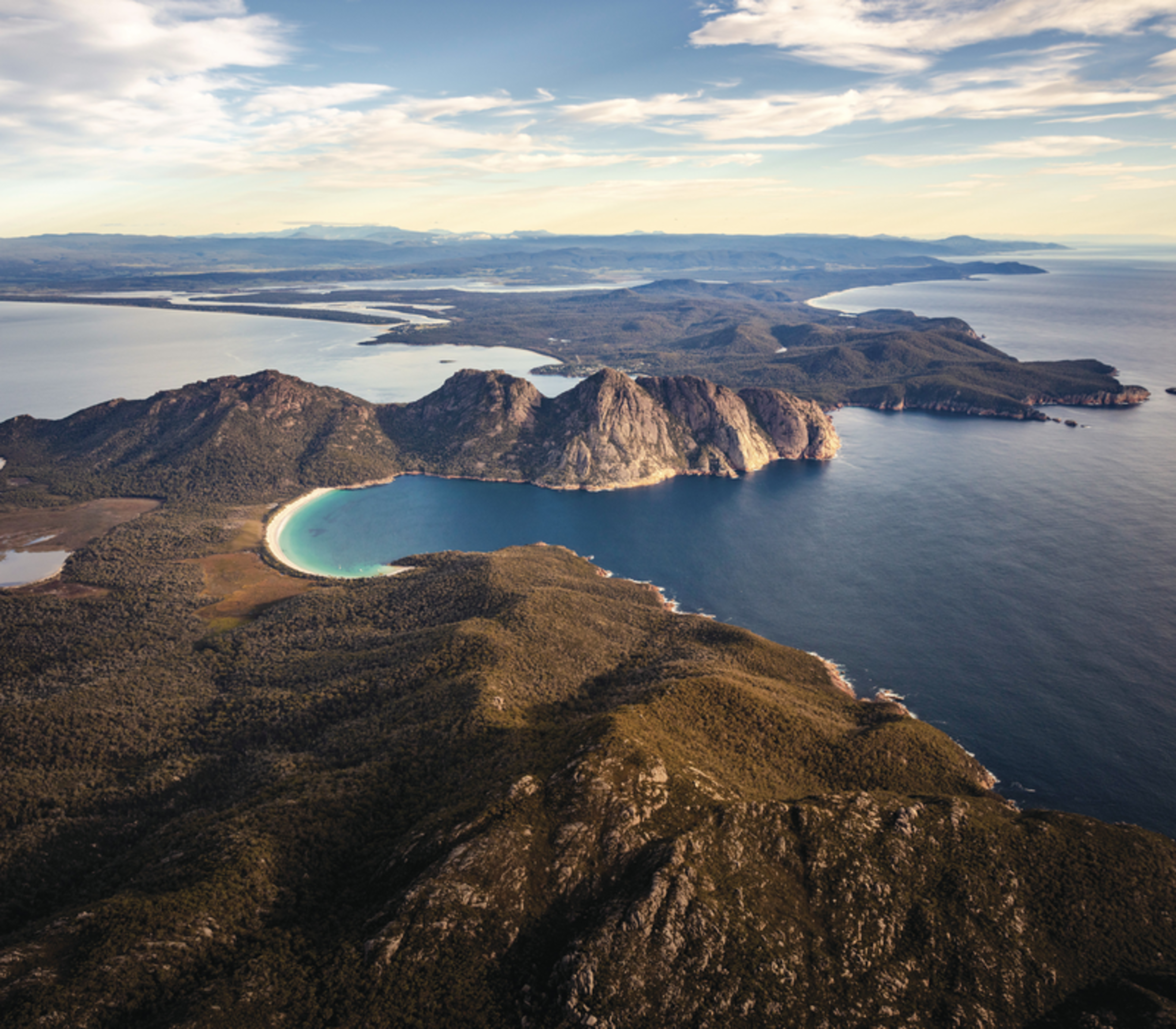 A stunning wide-angle aerial view of the Freycinet Peninsula, a highlight of any On Board Expedition Cruise in Tasmania.