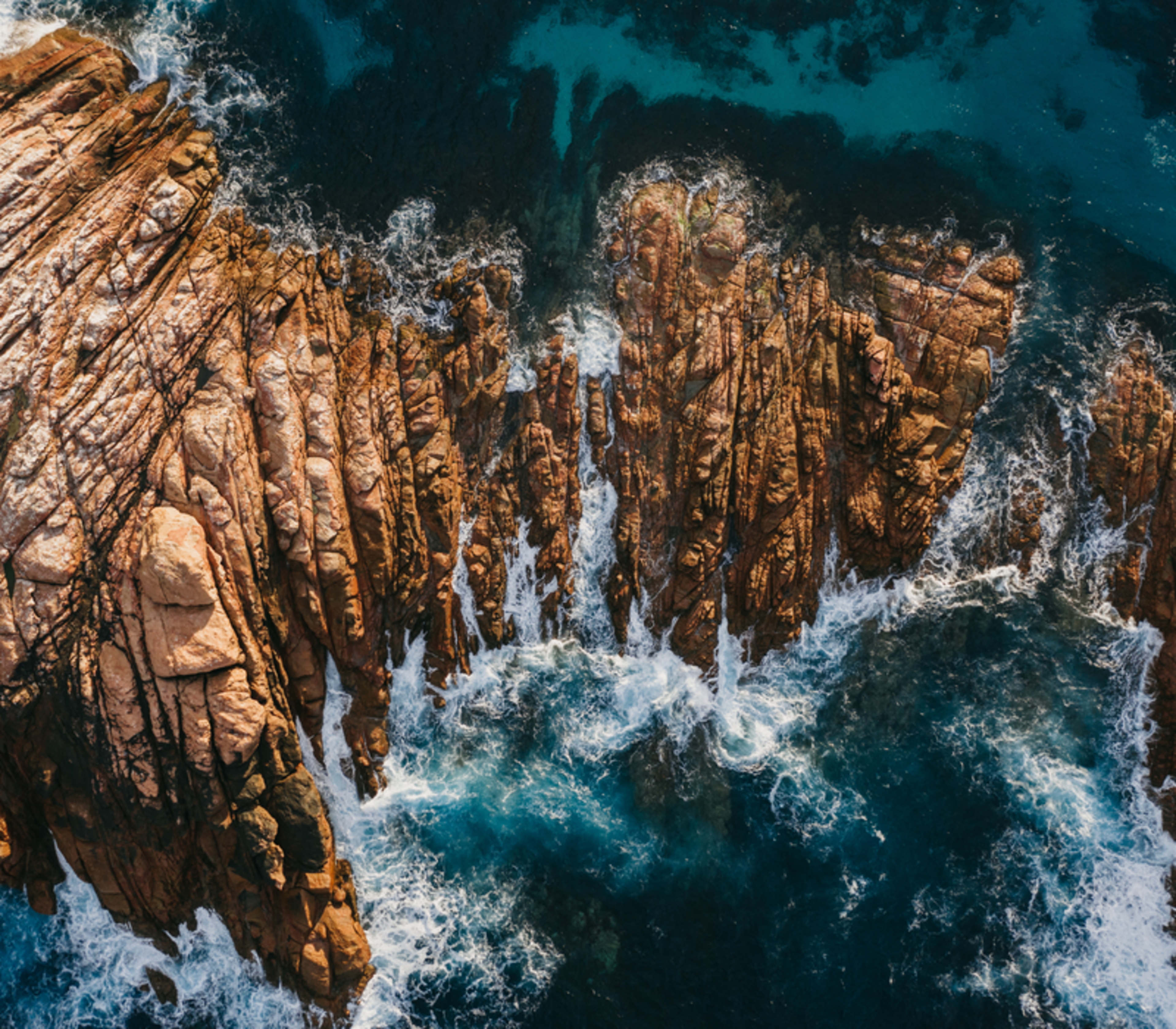 A stunning top-down aerial shot shows the white wash of the Indian Ocean surging through the narrow granite channels of Canal Rocks near Yallingup in the Margaret River region.